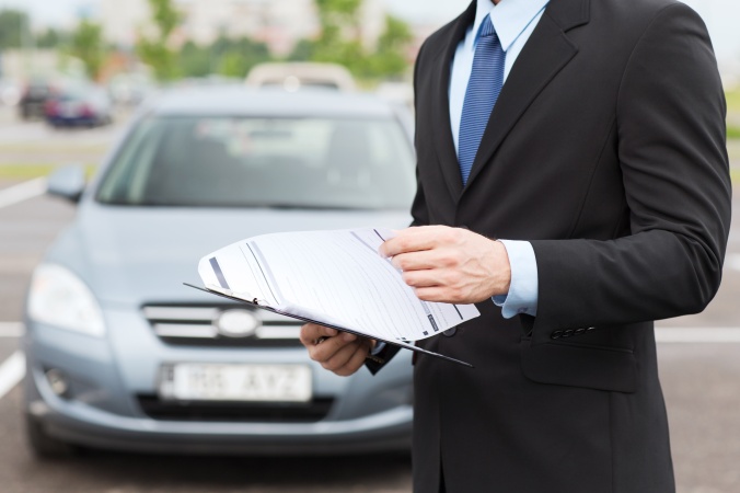 man with car documents outside